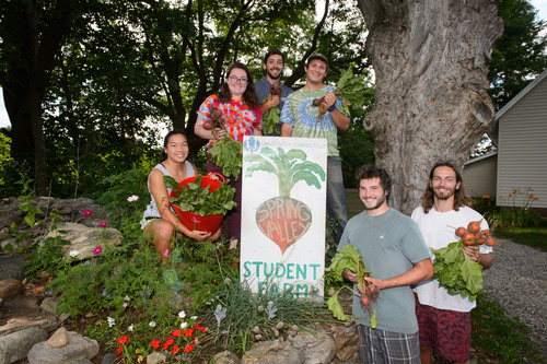 Students pose with vegetables at the Spring valley Student Farm.
